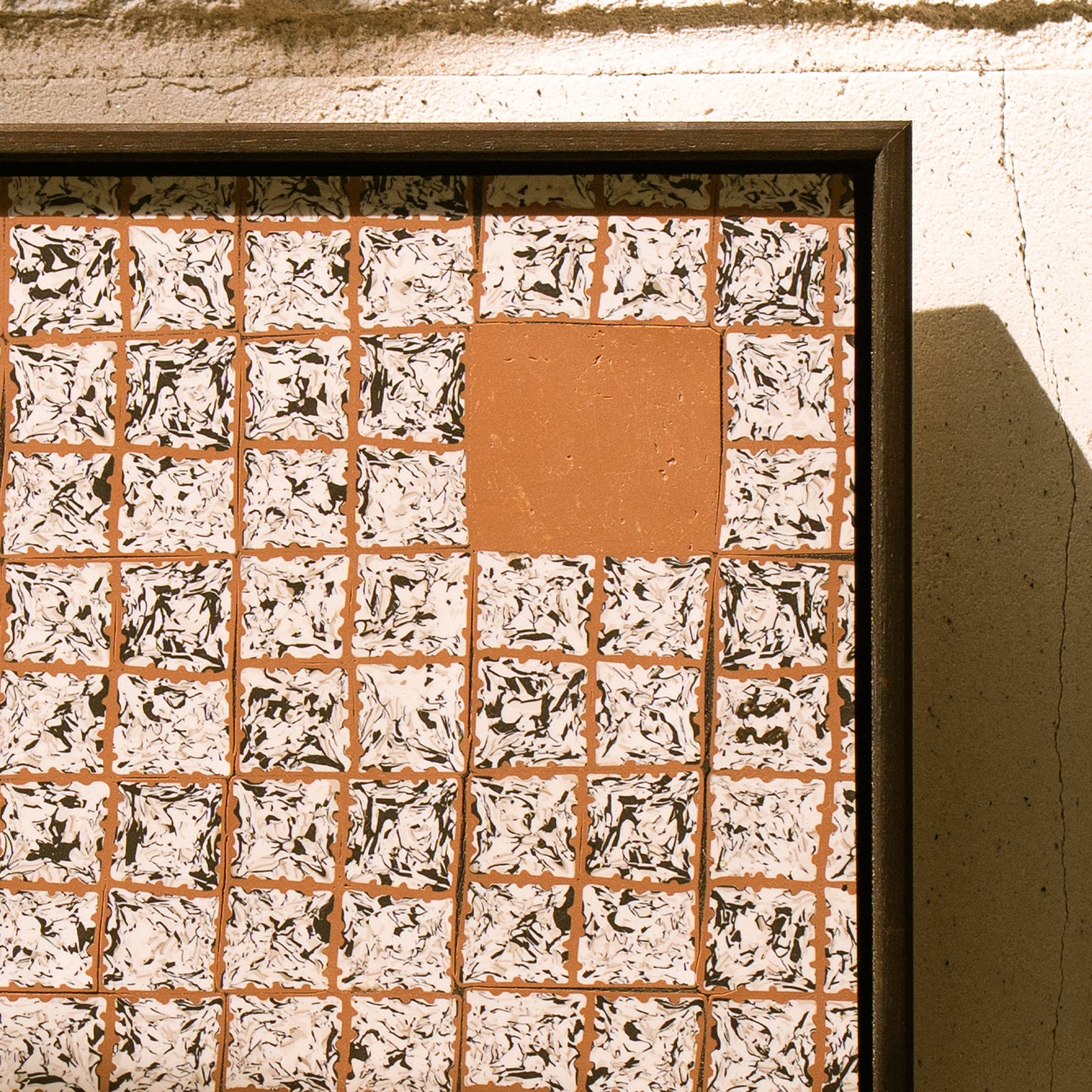 Greót II, contemporary abstract polymer clay artwork featuring a grid of textured black, white and terracotta square cane slices with solid terracotta blocks, framed in a dark English walnut stained wooden tray frame.