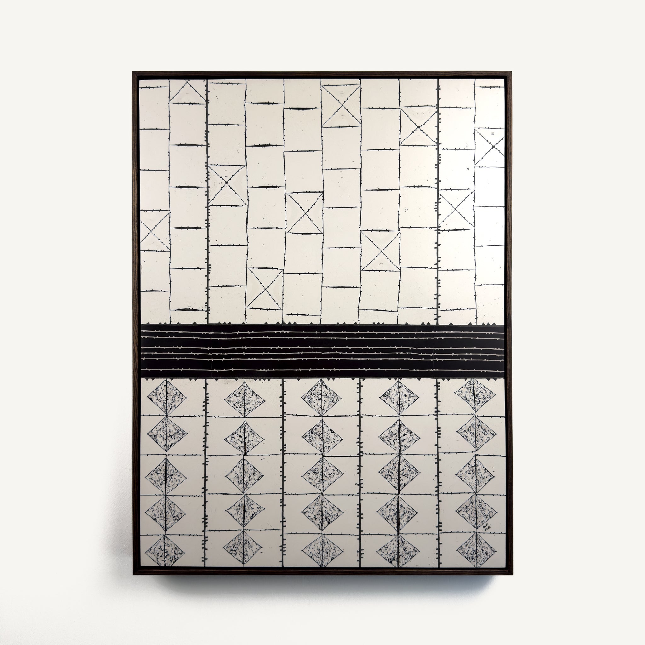 Ende, a contemporary abstract polymer clay artwork composed of geometric off-white and black forms arranged in a structured grid. The upper section features rectangular blocks interrupted by occasional crossed squares, while the lower section is defined by repeating diamond motifs. A bold horizontal dark brown black band divides the composition, creating a strong architectural balance between the two halves. Presented in a solid wood tray frame finished in dark English walnut, measuring 47.5 × 63 cm.