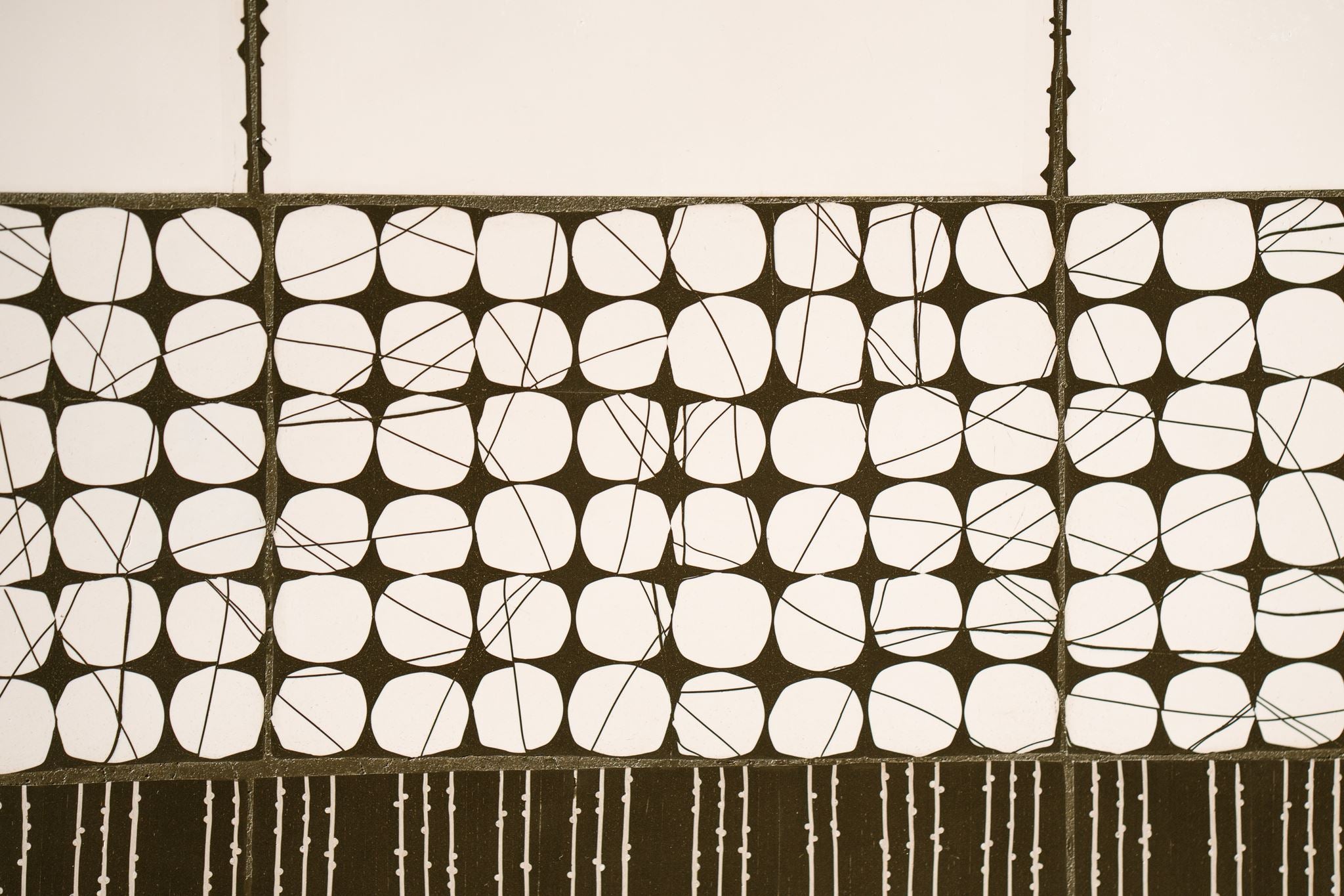 Close up of Heġe, a contemporary abstract polymer clay artwork by Anna Mills, zooming in on black-and-off white circular cane patterns.