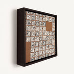 Greót II, at an angle, a contemporary abstract polymer clay artwork featuring a grid of individually sliced black, white and beige patterned squares arranged around open terracotta-coloured negative spaces. The composition is presented in a solid wood veneer tray frame finished in dark English walnut, measuring 17 × 17 cm.