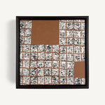 Greót I, by artist Anna Mills, a contemporary abstract polymer clay artwork featuring a grid of individually sliced black, white and beige patterned squares arranged around open terracotta-coloured negative spaces. The composition is presented in a solid wood veneer tray frame finished in dark English walnut, measuring 17 × 17 cm.