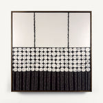 Heġe, a contemporary abstract polymer clay artwork measuring 52 × 52 cm, by artist Anna Mills. A minimalist composition combines a spacious off-white upper field with a central band of hand-cut organic geometric forms outlined by fine black lines, anchored by a bold black section of delicate vertical linework below. Subtle handcrafted textures and irregularities create a quiet balance between structure and organic movement. Presented in a solid wood tray frame finished in dark English walnut.