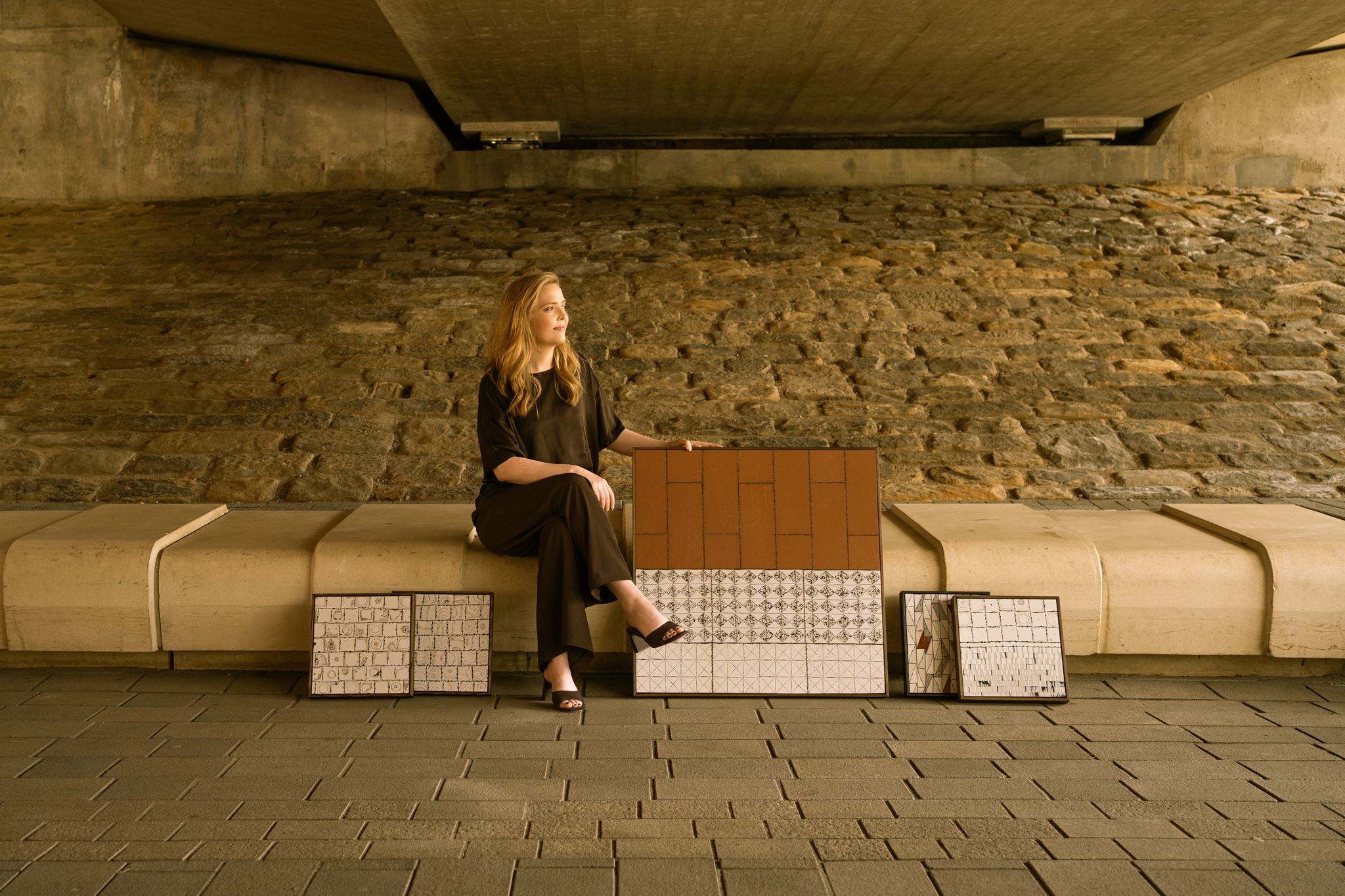 Artist Anna Mills with her contemporary polymer clay artworks in an architectural setting, reflecting the relationship between material, form and space.