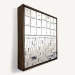 Wer, a contemporary abstract polymer clay artwork measuring 32 × 32 cm, by artist Anna Mills. A minimalist composition contrasts a grid of hand-cut ivory tiles with soft concentric forms above a field of finely sliced vertical clay strips below. Fine black linework, subtle marbled details and organic surface variations celebrate the handcrafted nature of the medium while balancing structure with quiet imperfection. Presented in a solid wood tray frame finished in dark English walnut.